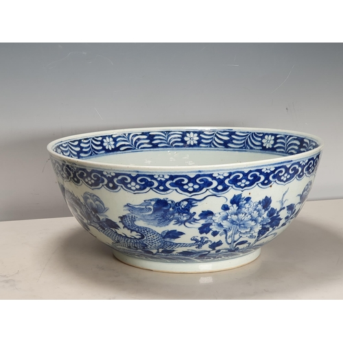 351 - A 19th Century Chinese large blue and white Bowl decorated dragons and flowers in a landscape with i... 