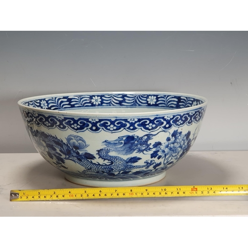 351 - A 19th Century Chinese large blue and white Bowl decorated dragons and flowers in a landscape with i... 