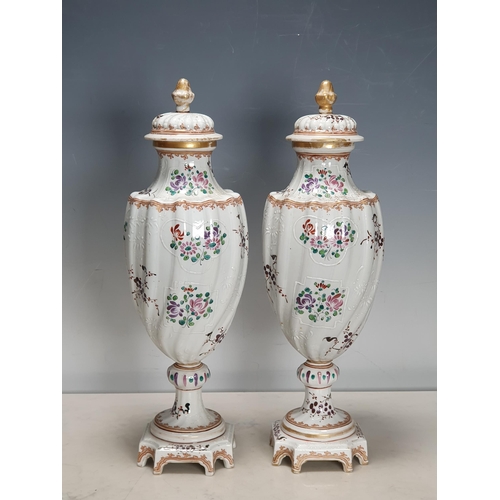 361 - A pair of Chinese armorial Vases and Covers of spiral moulding and decorated sprays of flowers on pe... 