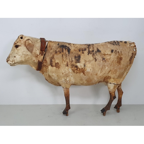 414 - An antique Folk Art skin covered wooden Model of a Shorthorn Cow with glass eyes A/F 14in L, and ano... 