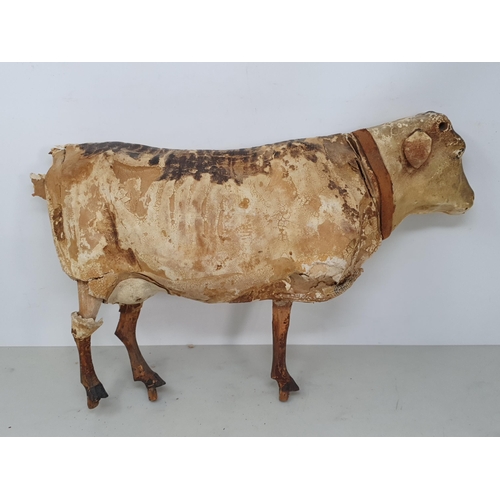 414 - An antique Folk Art skin covered wooden Model of a Shorthorn Cow with glass eyes A/F 14in L, and ano... 