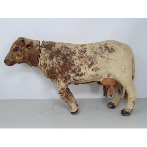 414 - An antique Folk Art skin covered wooden Model of a Shorthorn Cow with glass eyes A/F 14in L, and ano... 