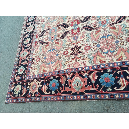 417 - A large modern Carpet with leafage design on cream ground within blue border 13ft 1in L x 10ft 4in W