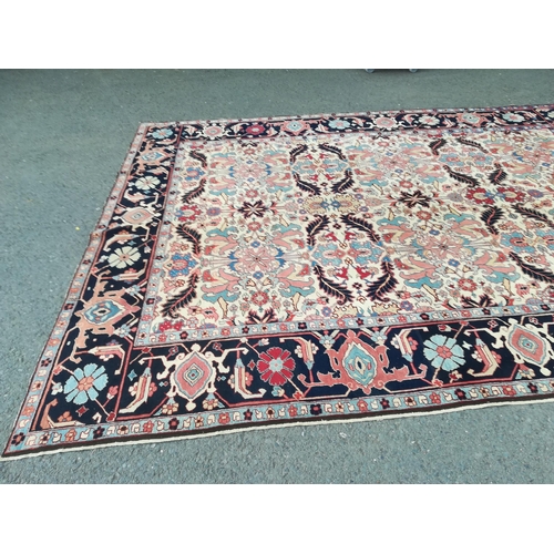 417 - A large modern Carpet with leafage design on cream ground within blue border 13ft 1in L x 10ft 4in W