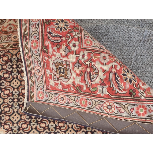 418 - A modern Persian Rug with pink central lozenge on blue ground with pink border with stylised flowers... 