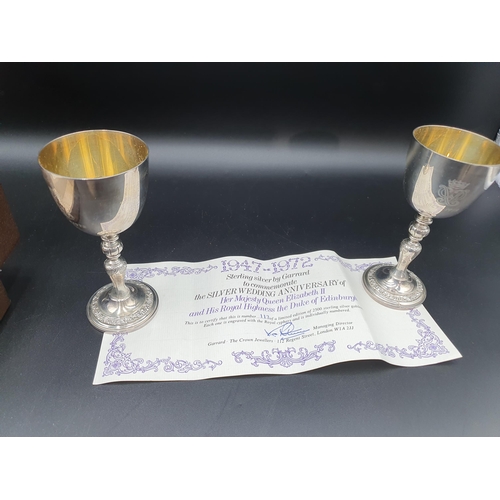 45 - A pair of Elizabeth II silver Limited Edition Silver Wedding Goblets on baluster columns decorated f... 