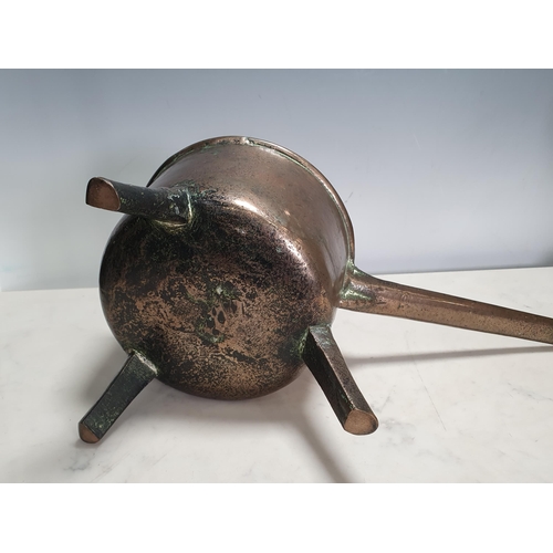 463 - An antique bell metal Skillet, the handle inscribed 'Warner' on three peg supports, 16in, including ... 