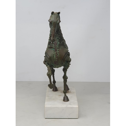 476 - WALENTY PYTEL. A patinated bronze Sculpture of a prancing horse, mounted on a white rectangular marb... 