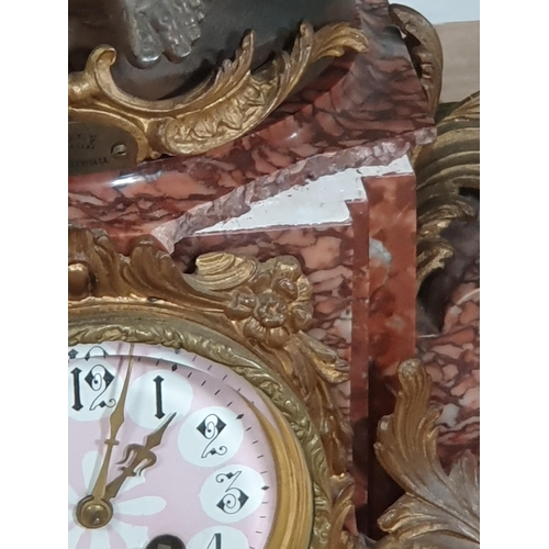 489 - A variegated red marble and gilt metal Clock Garniture, the clock having a large spelter winged cher... 