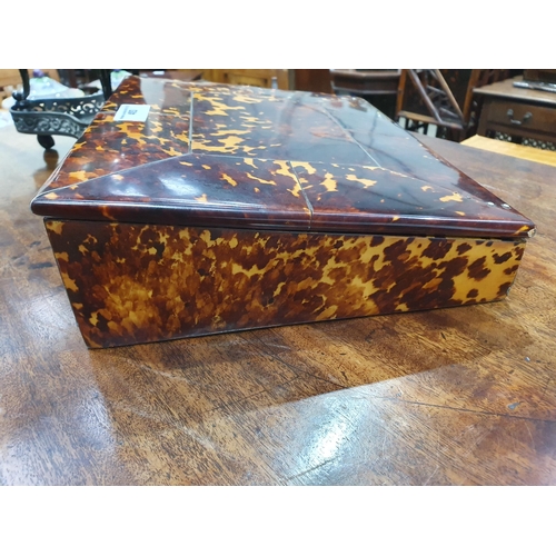 493 - A 19th Century tortoiseshell Writing Slope, the hinged lid enclosing red velvet writing surface, and... 