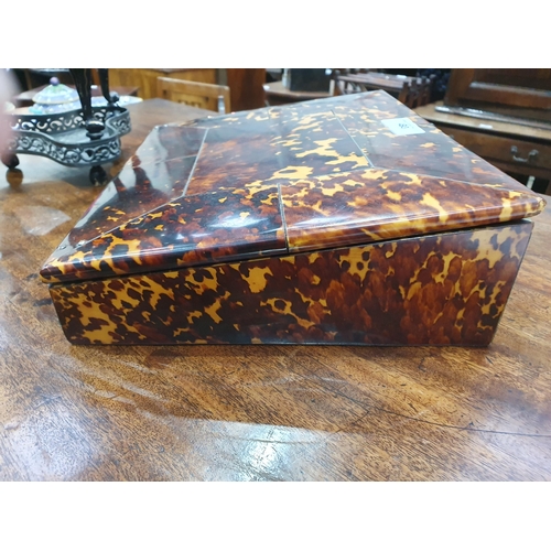 493 - A 19th Century tortoiseshell Writing Slope, the hinged lid enclosing red velvet writing surface, and... 