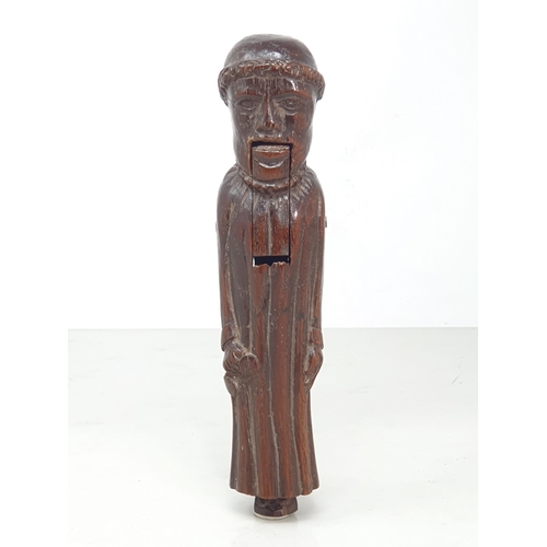 520 - An antique carved treen Nutcracker in the form of a Monk, 8 inches long