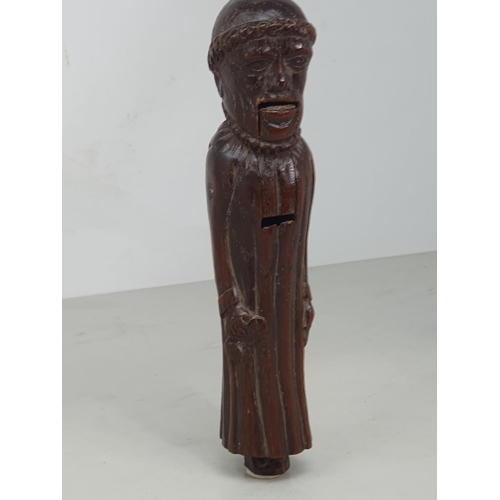 520 - An antique carved treen Nutcracker in the form of a Monk, 8 inches long