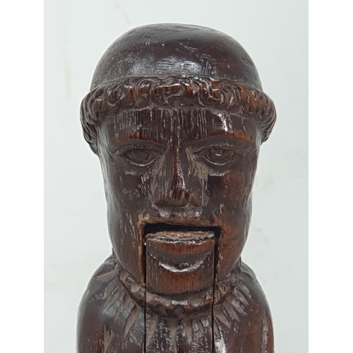 520 - An antique carved treen Nutcracker in the form of a Monk, 8 inches long