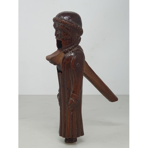 520 - An antique carved treen Nutcracker in the form of a Monk, 8 inches long