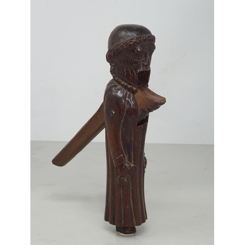 520 - An antique carved treen Nutcracker in the form of a Monk, 8 inches long