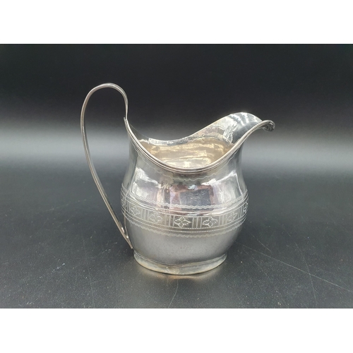 65 - A George III silver oval Jug engraved leakage friezes with shaped cartouche and reeded rims, London ... 