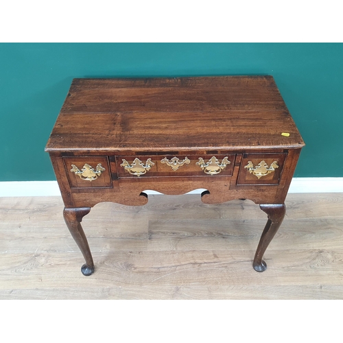 746 - An 18th Century oak Lowboy fitted three crossbanded drawers above a shaped frieze and raised on four... 