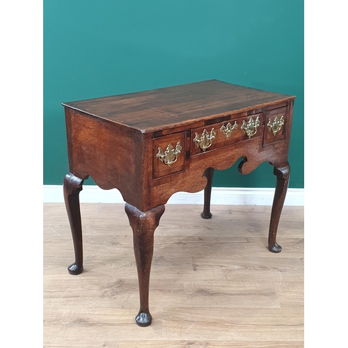 746 - An 18th Century oak Lowboy fitted three crossbanded drawers above a shaped frieze and raised on four... 