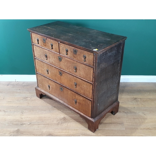 797 - An 18th Century oak and walnut veneered Chest of two short, three long graduated Drawers raised on b... 