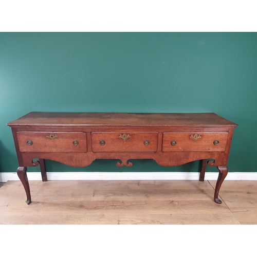 813 - An 18th Century oak Dresser Base with moulded top above three drawers and a shaped frieze on cabriol... 