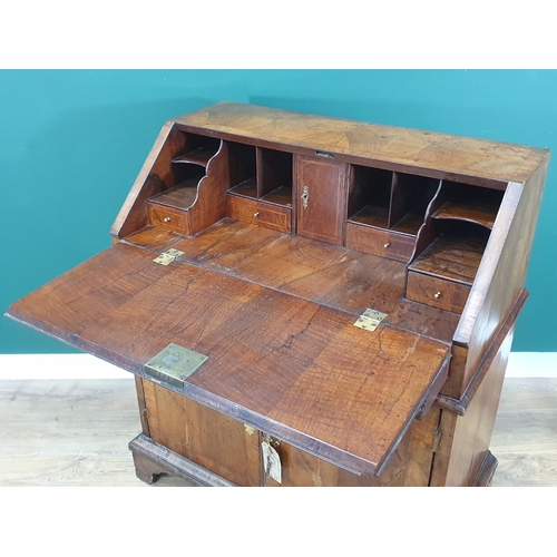 822 - An 18th Century figured walnut veneered Bureau with sloped fall front enclosing four drawers, a cent... 