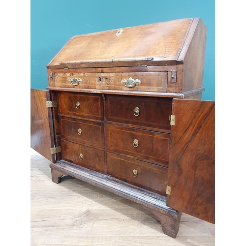 822 - An 18th Century figured walnut veneered Bureau with sloped fall front enclosing four drawers, a cent... 