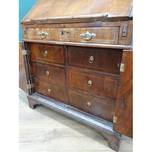 822 - An 18th Century figured walnut veneered Bureau with sloped fall front enclosing four drawers, a cent... 