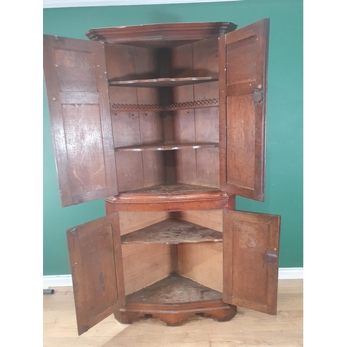 829 - A George III oak Double Corner Cupboard with panelled doors enclosing shaped shelves, 6ft 6in H (Mar... 