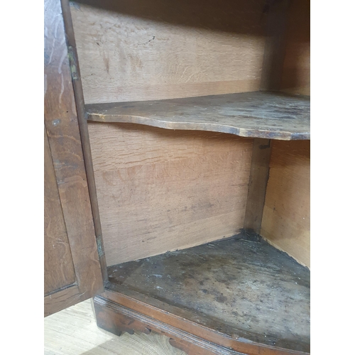 829 - A George III oak Double Corner Cupboard with panelled doors enclosing shaped shelves, 6ft 6in H (Mar... 