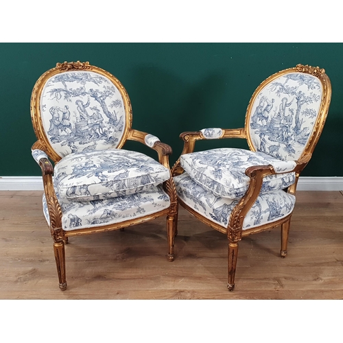 834 - A pair of French gilded open Armchairs, moulded top rails in the form of musical instruments with bl... 