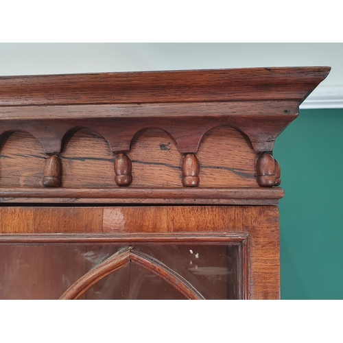 844 - A Gothic oak Bookcase with moulded cornice above a pair of astragal glazed doors enclosing adjustabl... 