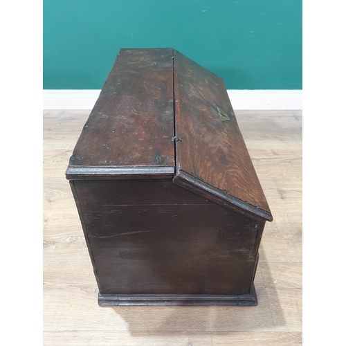 852 - An 18th Century oak slope fronted Desk Box, the hinged lid enclosing two pigeon holes above four pan... 