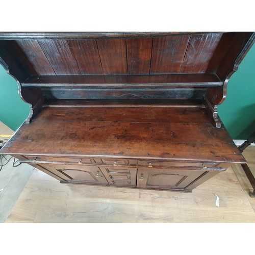 868 - An 18th Century oak Welsh Dresser and Rack, the enclosed shelves with moulded cornice, the base fitt... 