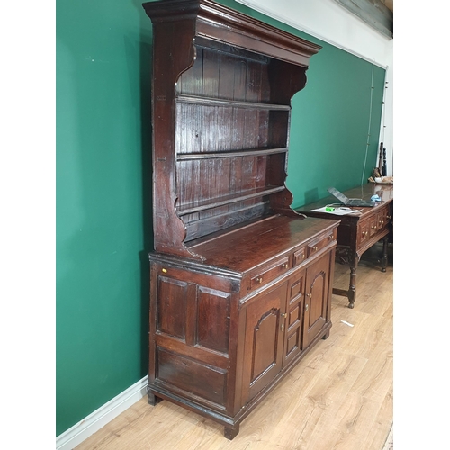 868 - An 18th Century oak Welsh Dresser and Rack, the enclosed shelves with moulded cornice, the base fitt... 