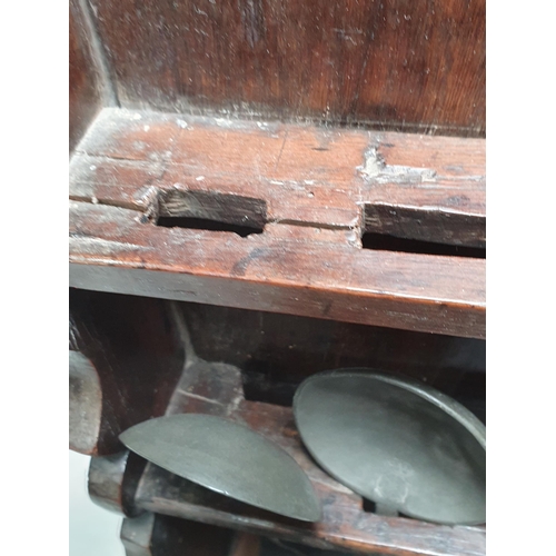 869 - An 18th Century oak Spoon Rack with arched top and two tiers of slots for spoons and containing five... 