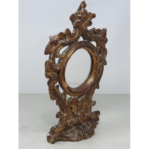 870 - An 18th Century carved and gilt Table Mirror with scroll and floral pierced surmount, with circular ... 