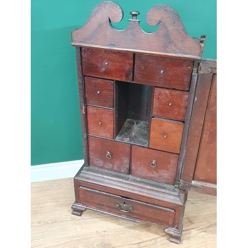 885 - An early 18th century oak Table Top Spice Cupboard, the broken pediment top above a single door encl... 