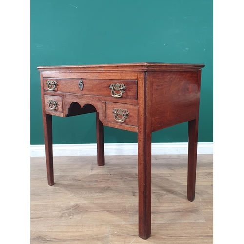 889 - A Georgian mahogany Lowboy fitted three drawers around a shaped frieze on chamfered squared supports... 