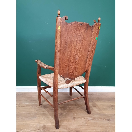 908 - A carved oak Eisteddfod Elbow Chair the back carved with dragon in a panel and dated 1917, with rush... 