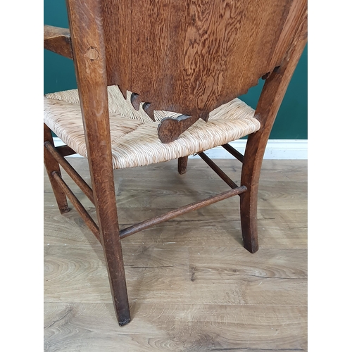 908 - A carved oak Eisteddfod Elbow Chair the back carved with dragon in a panel and dated 1917, with rush... 