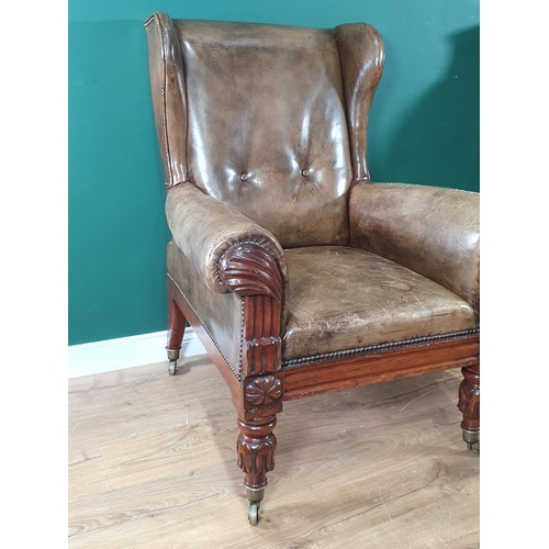 912 - A William IV mahogany  Wingback Library Chair with carved decoration to the arm fronts and raised on... 