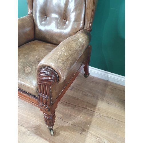 912 - A William IV mahogany  Wingback Library Chair with carved decoration to the arm fronts and raised on... 