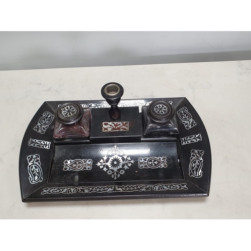 921 - An ebonised Desk Stand with floral inlay designs in mother-of-pearl having covered inkwells and Cand... 