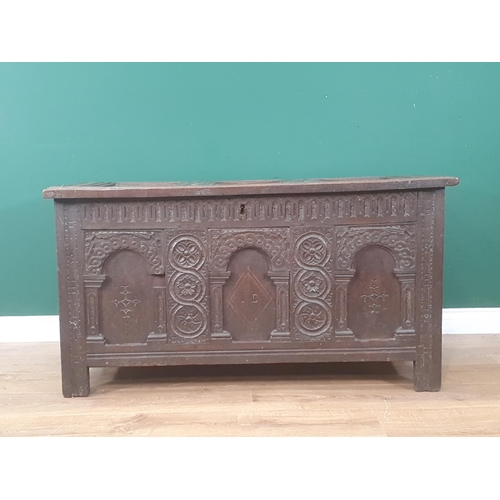 938 - An early 17th Century oak Coffer with sunken three panel lid above nulled frieze and three arched pa... 