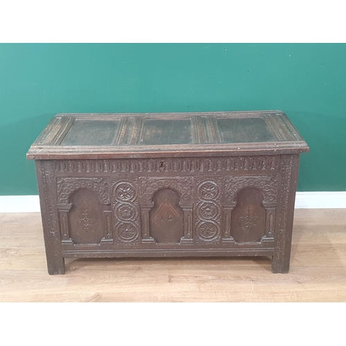 938 - An early 17th Century oak Coffer with sunken three panel lid above nulled frieze and three arched pa... 