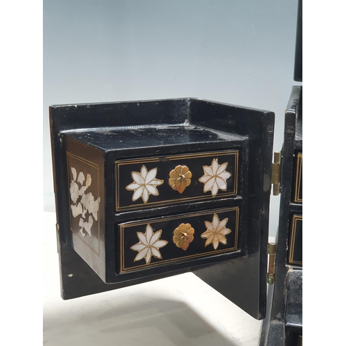 943 - An Oriental Cabinet fitted assorted small drawers and a folding mirror, decorated chinoiserie figure... 