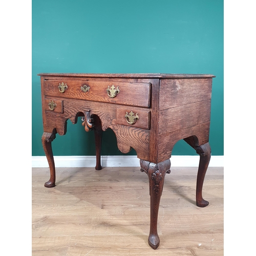 947 - An 18th Century oak Lowboy with moulded top above three drawers on a shaped frieze, raised on cabrio... 