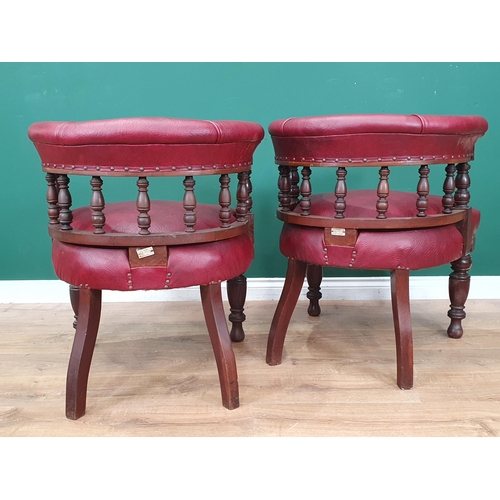 961 - A pair of mahogany and upholstered Library Chairs with carved backs and turned front supports, label... 