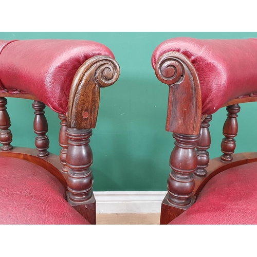 961 - A pair of mahogany and upholstered Library Chairs with carved backs and turned front supports, label... 